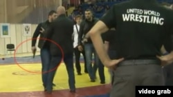 A screen grab from a YouTube video appears to show a man brandishing a gun during a melee that broke out during a wrestling match in Russia.