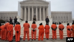 Hooded demonstrators take part in a rally in January in front of the U.S. Supreme Court on Capitol Hill in Washington to call for the closing of the Guantanamo Bay detention center.