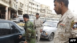 Disarmed members of the Sahwa militia that helped oppose Al-Qaeda influence man a checkpoint in Baghdad in April 2009.