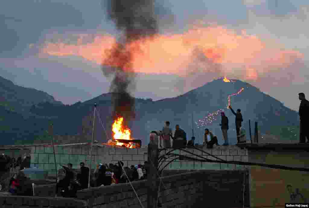 Locals gather around a bonfire as the torch procession winds up a hill above Aqrah, in northern Iraq, on March 20.