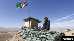 An Afghan National Army (ANA) soldier keeps watch at a check post in Logar province.