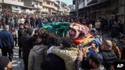 Relatives and neighbors attend the funeral procession for four Syrian security force members killed in clashes with loyalists of ousted President Bashar al-Assad in coastal Syria on March 8.