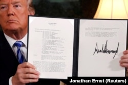 U.S. President Donald Trump holds up a proclamation in May 2018 declaring his intention to withdraw from the 2015 Iran nuclear agreement.