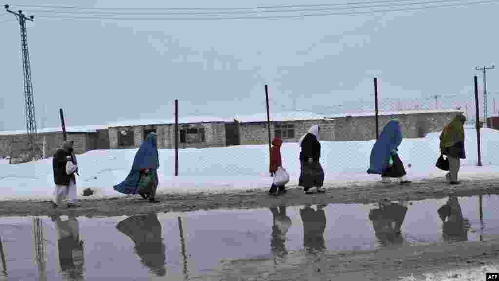 Afghans walking along a street in Kabul in February.