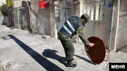 Iranian police remove satellite dishes from roofs in east Tehran in late February.