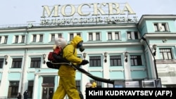 Servicemen of Russia's Emergency Situations Ministry wearing protective gear disinfect Moscow's Belorussky railway station on October 20 amid the ongoing COVID-19 pandemic.