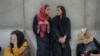 Afghan women wait in front of a bank office in Kabul on September 20, weeks after the Taliban seized power.