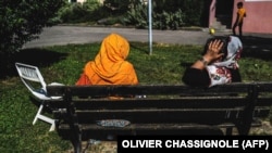 Two Afghan women sit on a bench after their evacuation from Kabul, in Villeurbanne, near Lyon, in 2021. 