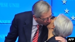 Eurogroup President Jean-Claude Juncker kisses International Monetary Fund (IMF) Managing Director Christine Lagarde after a press conference in Brussels on February 21 announcing the terms of the Greek bailout, the second in under two years.