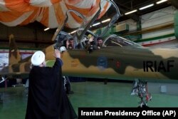 Iranian President Hassan Rohani waves to the pilots of a fighter jet before an inauguration ceremony of the aircraft on August 21.