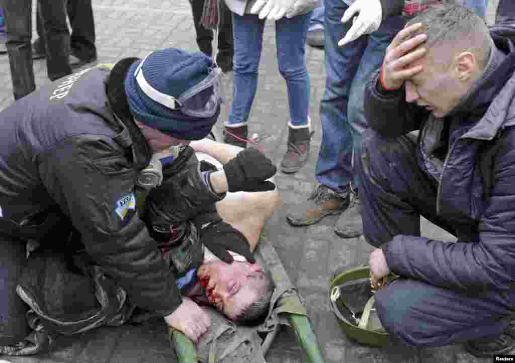 A wounded protester is attended to before being rushed away to receive medical help.