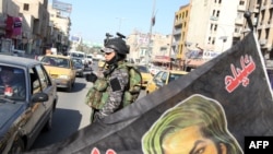 An Iraqi soldier mans a checkpoint in Baghdad to secure the return of Shi'ite Muslim pilgrims from the city of Karbala 