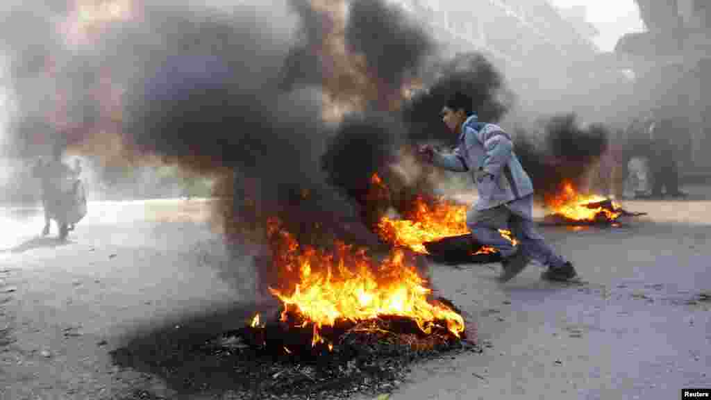 An Afghan boy runs next to fire during a protest in Jalalabad on February 22.