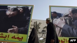 Iraqis walk past posters of Prime Minister Nuri al-Maliki in the Bab al-Sharqi district of Baghdad this month.