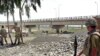 Pakistani soldiers inspect a bridge over the Kurram River. Can development go forward when military operations are driving people from their homes?