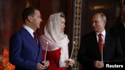 Russian President Vladimir Putin, Prime Minister Dmitry Medvedev and his wife Svetlana attend the Orthodox Easter service at the Christ the Savior Cathedral in Moscow on April 7.