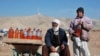 A man and his son sell fuel packed in water bottles on the outskirts of the Afghan city of Herat, near the western border with Iran, a result of the recent Iranian blockade.