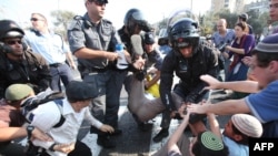 Israeli riot police detain a protester after Israeli students rallied against a plan to continue the construction freeze in the West Bank.