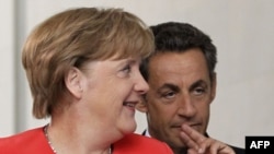 German Chancellor Angela Merkel and French President Nicolas Sarkozy arrive to address a news conference at the Chancellery in Berlin on June 17.