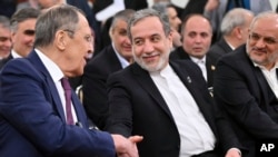 Russian Foreign Minister Sergei Lavrov, left, and Iranian Foreign Minister Abbas Araghchi shake hands after their talks in Moscow on January 17. 