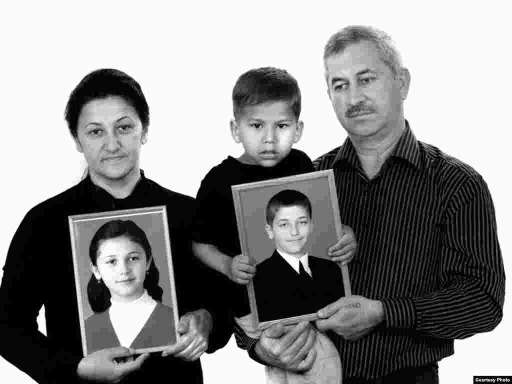 Elvira (left), Artur, and Georgy Tuayev, holding portraits of Karina (seventh grade) and Khetaga (fifth grade) - The family remembers Karina balking on the first day of school: “I don't want to go! Let's go home!” “She had a premonition -- why didn't I listen to her?" her grieving mother, Elvira, asks. She went with her two children to the first-day assembly. A three-day nightmare followed that ended with Elvira being carried out alive. Her children didn't survive. Three years later, Elvira was invited to the United States to talk about her ordeal. "I thought, God, what am I going to talk about? There was a room full of people, a table full of food. I remember, I picked up a glass of water and looked at it, and it all just rushed out of me. 'Do you know what a drop of water is? What it tastes like? How much you can crave it? I sat and watched as people were dying in front of me, not eating, not drinking.' I told them everything -- how we sat, how thirsty we were, how we drank urine fr