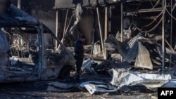 A man stands among debris next to a building destroyed after a drone attack in Odesa on March 8. 