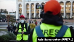 Journalists from RFE/RL's Kyrgyz Service, known locally as Radio Azattyk, report from outside the parliament building in Bishkek in December 2020.