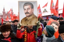 Russian communists hold portraits of Josef Stalin as they gather to mark his 139th birthday on Red Square in Moscow on December 21, 2018.