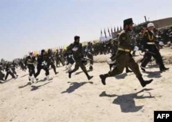 Afghan soldiers take up positions after shots are fired at the Kabul military parade on April 27, 2008.