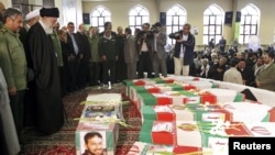 Supreme Leader Ayatollah Ali Khamenei (second from left) and Revolutionary Guards commander Mohammad Ali Jafari (left) stand next to the coffins of 17 members of the Revolutionary Guards who were killed in a blast at a military base last week.