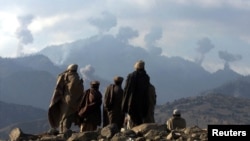 Afghan anti-Taliban fighters watch explosions from U.S. bombing in the Tora Bora Mountains in December 2001.