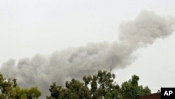 A smoke plume rises over Tripoli early on June 7, which correspondents say appeared to be in the vicinity of Muammar Qaddafi's residential compound.