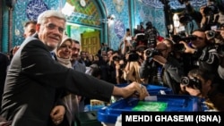 The head of the reformists' coalition list in the February vote, Mohammad Reza Aref, shows his inked finger after casting his ballot at a polling station in Tehran.