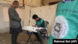 An Afghan employee of the Independent Election Commission registers a voter in Kabul in April.