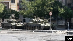 Syrian Army tanks are seen in the Al-Midan area of Damascus.