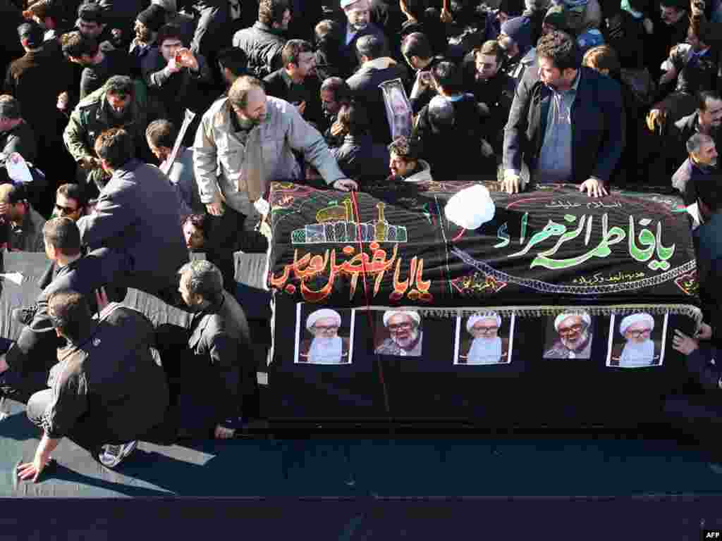 The coffin of Montazeri, who was one of the highest Shi'ite authorities, passes through mourners.