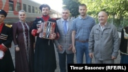 Eugen Martens (second from right) was greeted at the Stavropol railway station by Vladimir Poluboyarenko (right) and his lawyer, Aleksei Abazov, and an amateur musical group that performed a Cossack song and dance.