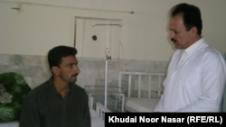 Dr. Ghulam Rasool (right) speaks to a patient.