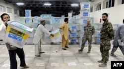 Afghan election-commission workers move ballot boxes to a truck for delivery to Kabul for an audit of the presidential runoff votes in the western Herat Province last month.