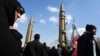 Supporters of the Islamic republic march past ballistic missile models in Tehran during the 46th anniversary of the Islamic revolution, February 10