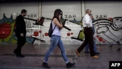 People walk outside a closed post office in Athens on the first day of Greece's 48-hour general strike on November 6.