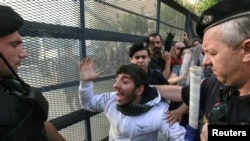 A demonstrator confronts riot police outside the Greek parliament in Athens on June 15.