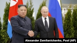 Russian President Vladimir Putin (right) and North Korean leader Kim Jong Un shake hands during a meeting in Vladivostok, Russia, in April 2019.