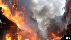 Flames rise from the scene of a powerful bomb blast at a Peshawar market.