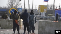 Pro-Russian servicemen man a position at the Chongar checkpoint on March 7, blocking a road into Crimea.