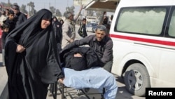 Residents wheel a stretcher carrying a wounded woman after a bomb attack targeted Shi'ite pilgrims commemorating a religious ceremony in Karbala.