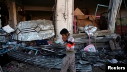 A boy reacts as he walks past the site of a bomb attack in a Shi'ite Muslim area in Quetta that killed more than 80 people. 