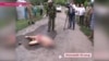 Local residents surround the body of Aleksandr Tsukerman in the middle of a dirt road in the southern village of Krivoye Ozero.