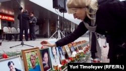 A woman looks at photographs of victims at a commemoration ceremony recalling the Dubrovka theater in Moscow, which resulted in 130 deaths.