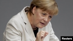 German Chancellor Angela Merkel addresses a session of the Bundestag at the Reichstag in Berlin on September 12.